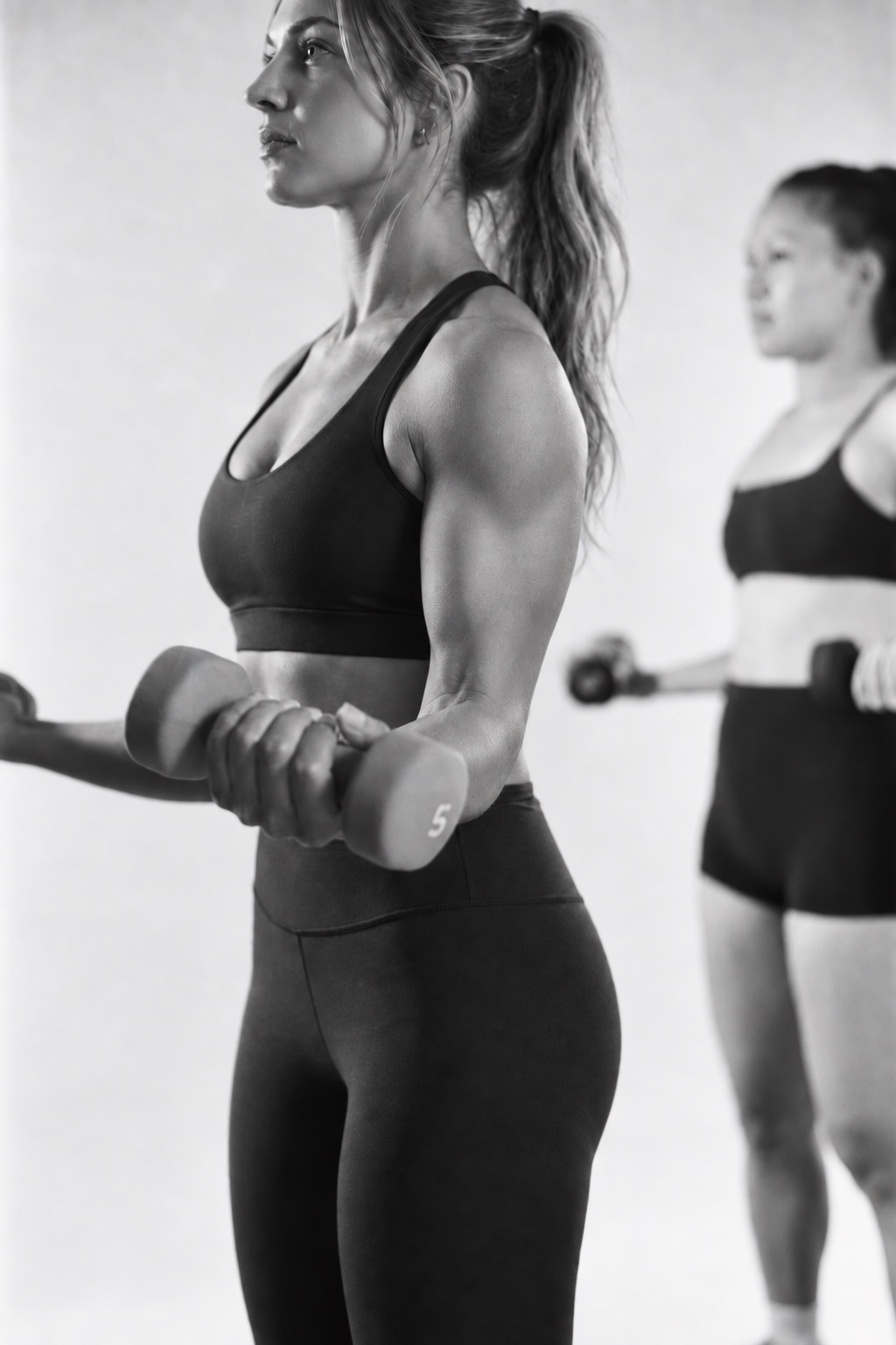 Members doing dumbbell bicep curls during class at Powered